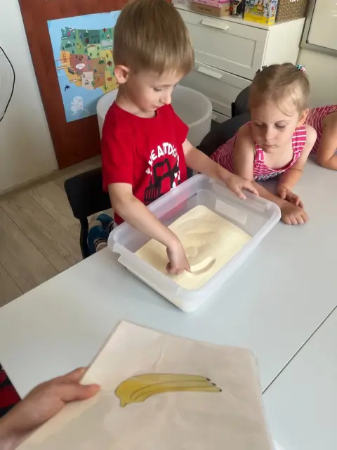 Chłopiec ogląda kartę świnki przez lupę