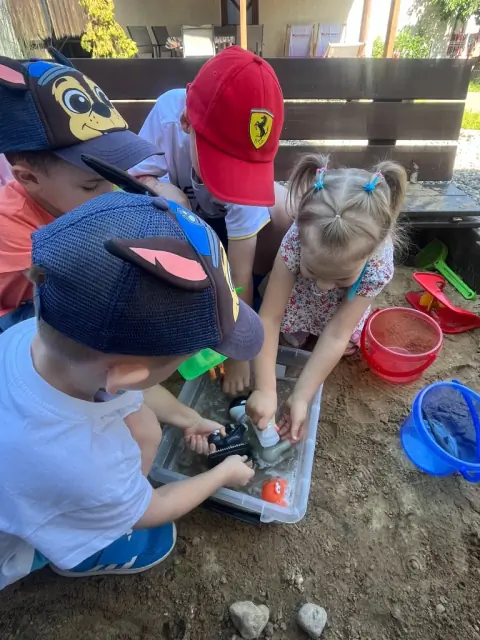 Troje dzieci przy Sensory Box z fasolą i pomponami