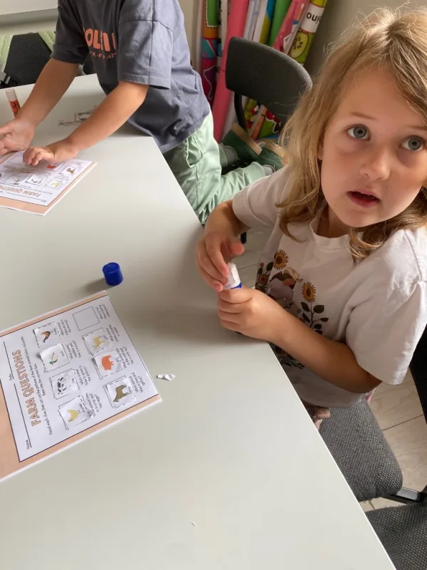 Uśmiechnięta dziewczynka przy Sensory Box podczas zajęć Sensory English