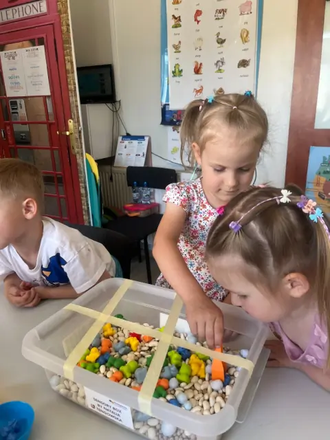 Dzieci wyciągają figurki zwierząt z Sensory Box pęsetą