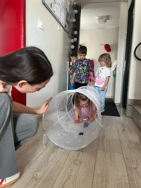 Dziewczynka czołga się przez tunel z figurkami zwierząt