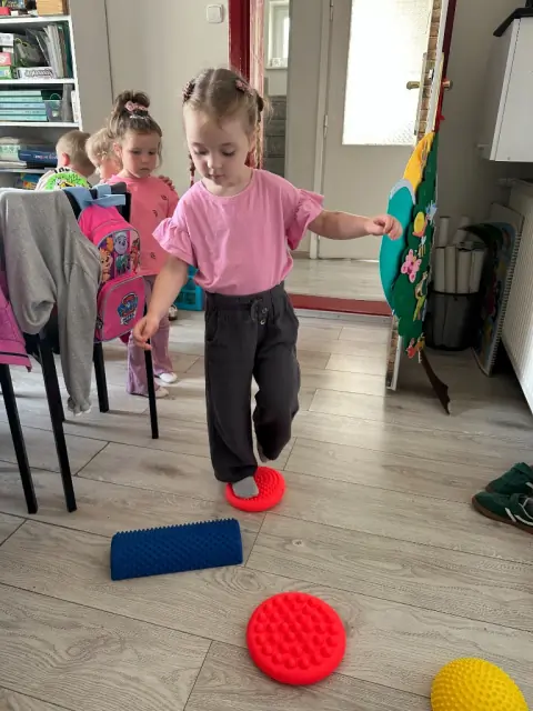 Dziewczynka stoi na wypukłych krążkach sensorycznych